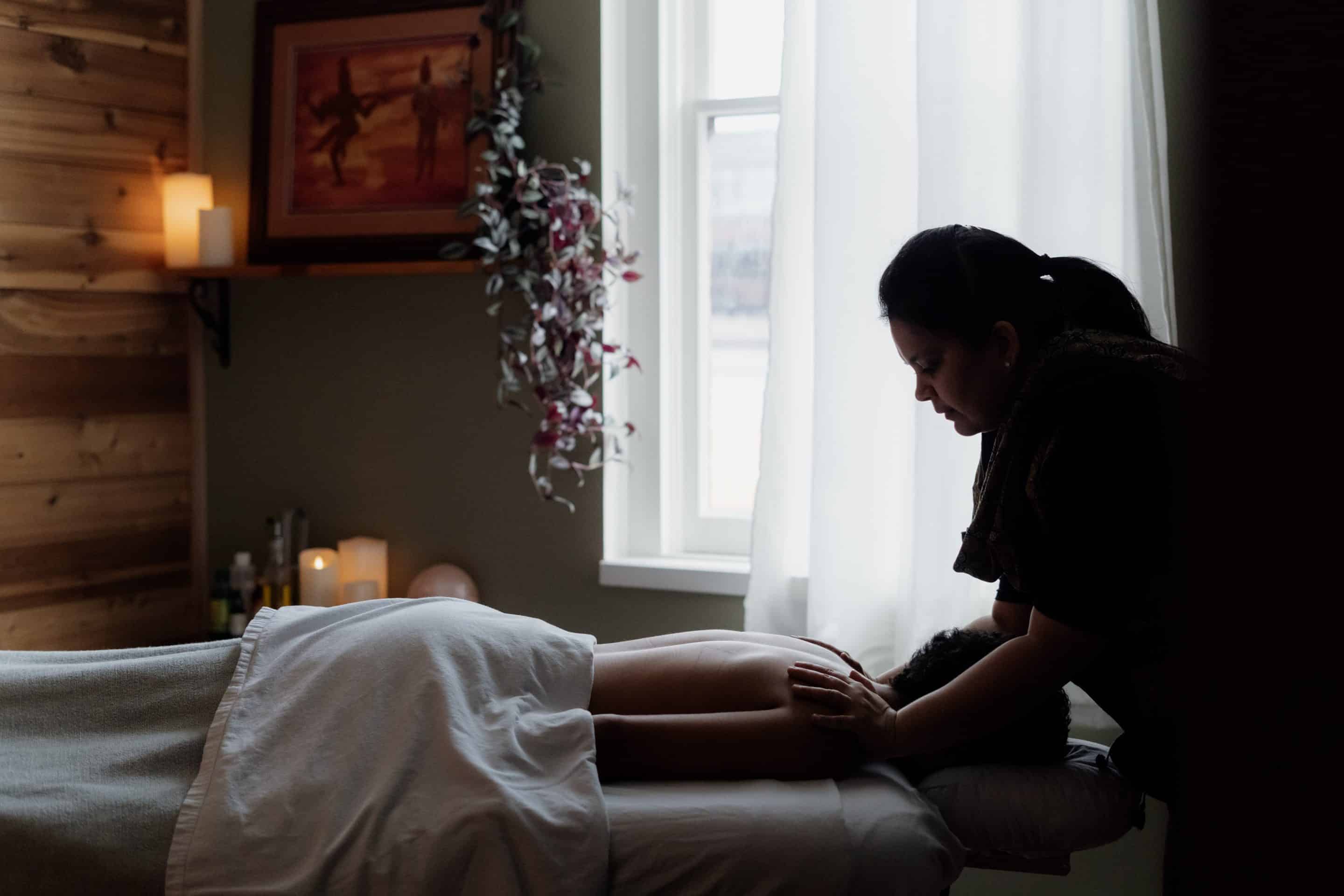 Massage therapist in Victoria giving a shoulder massage in a beautiful room