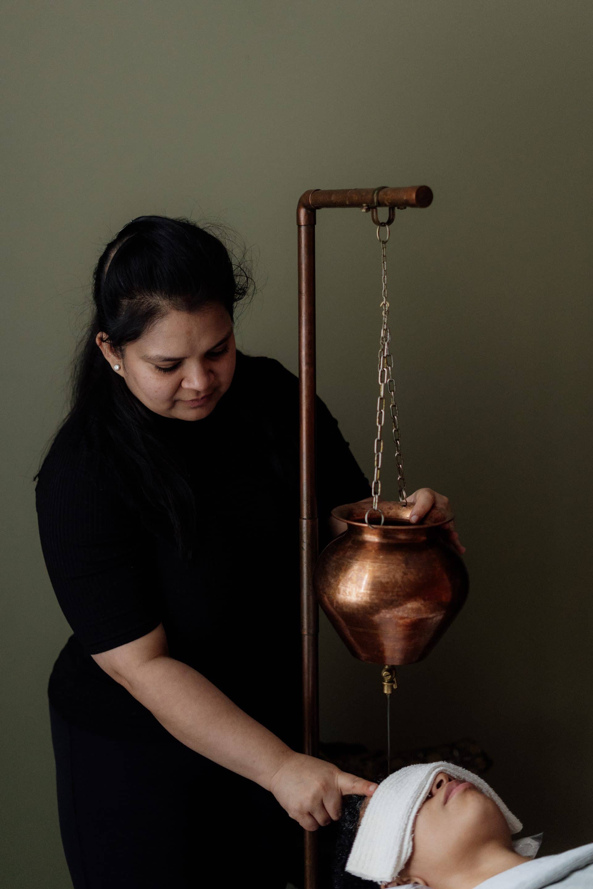 Woman about to give an Ayurvedic Shirodhara massage