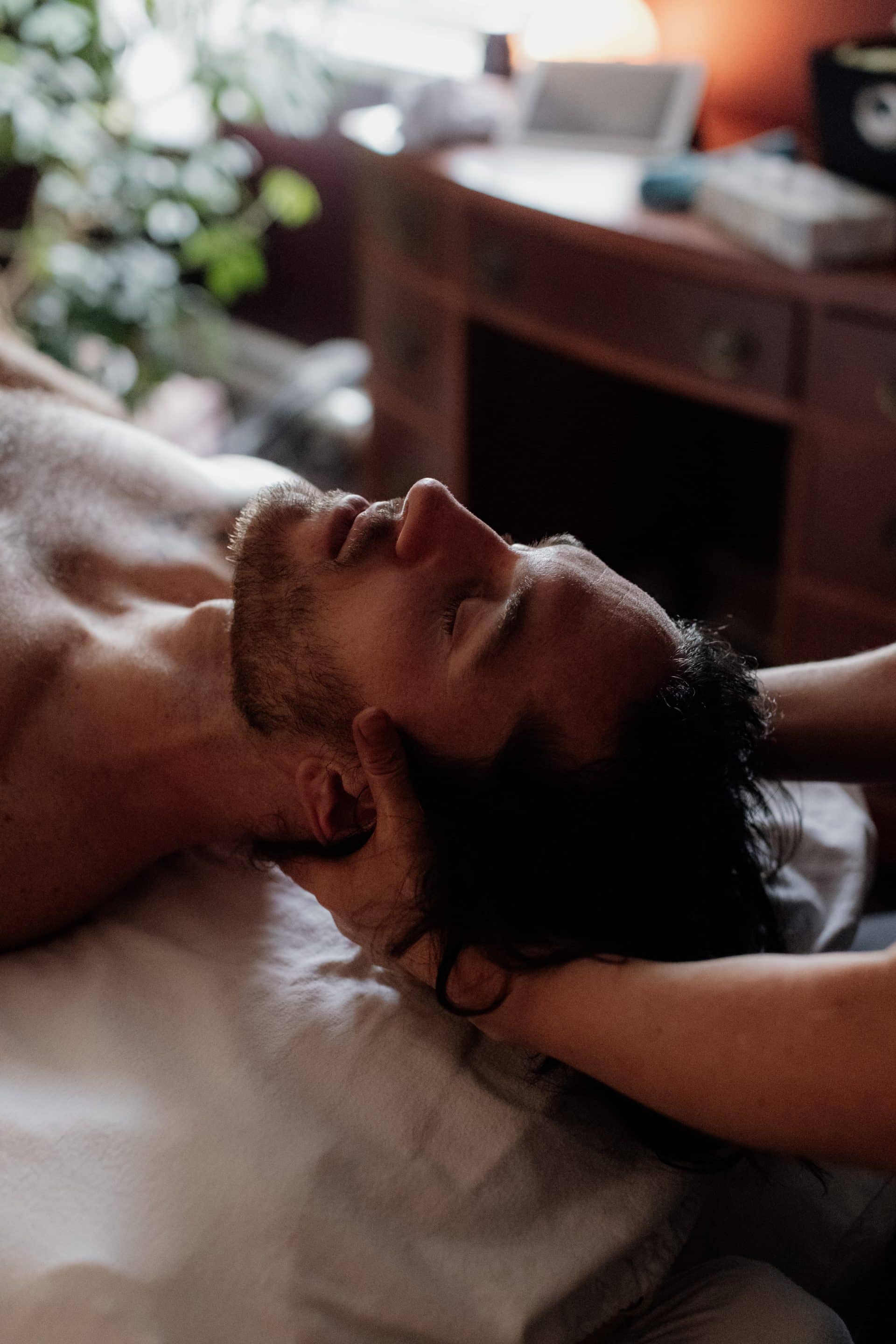 Man receiving a relaxing head massage for improved sleep quality.