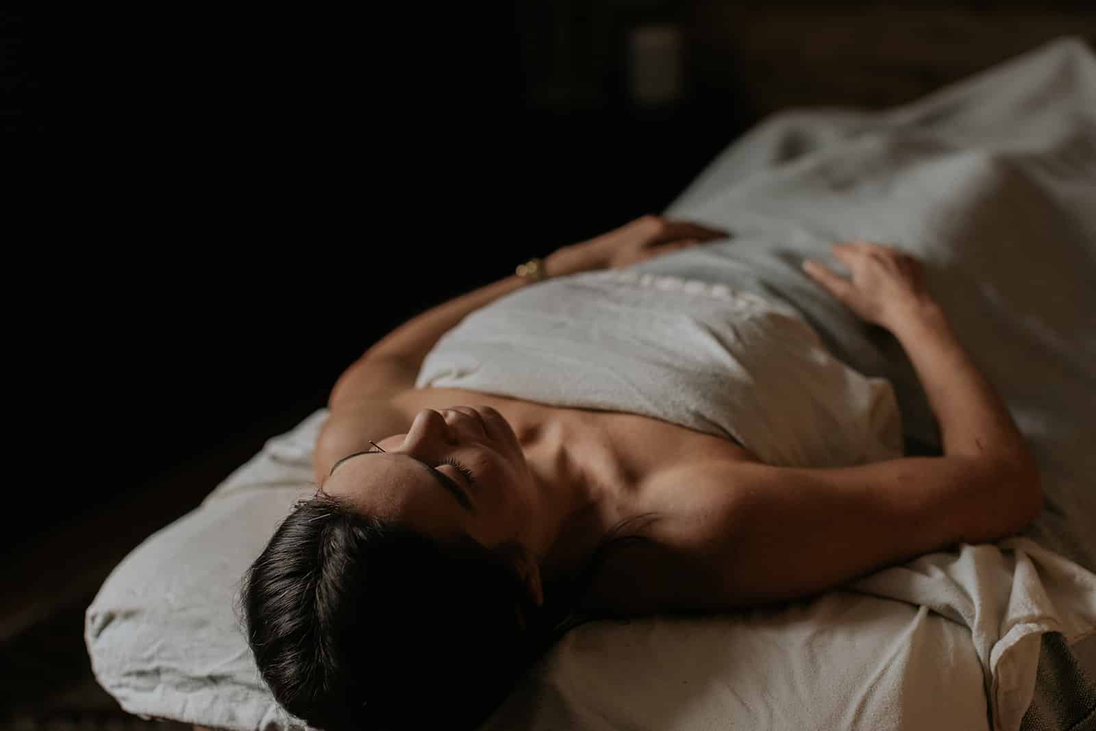 Woman receiving acupuncture treatment for fertility on a treatment bed, embodying the holistic journey to enhanced reproductive health.